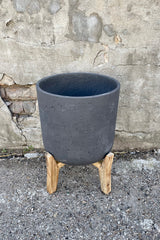 Detail of the top of the Charlie Pot & low stand black washed extra large against a grey wall
