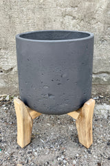 Detail of Patt Pot w/ Low Feet Black Washed Extra Large against a grey wall