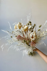 Large Pillow Talk preserved dried floral arrangement by Sprout Home held in front of white background