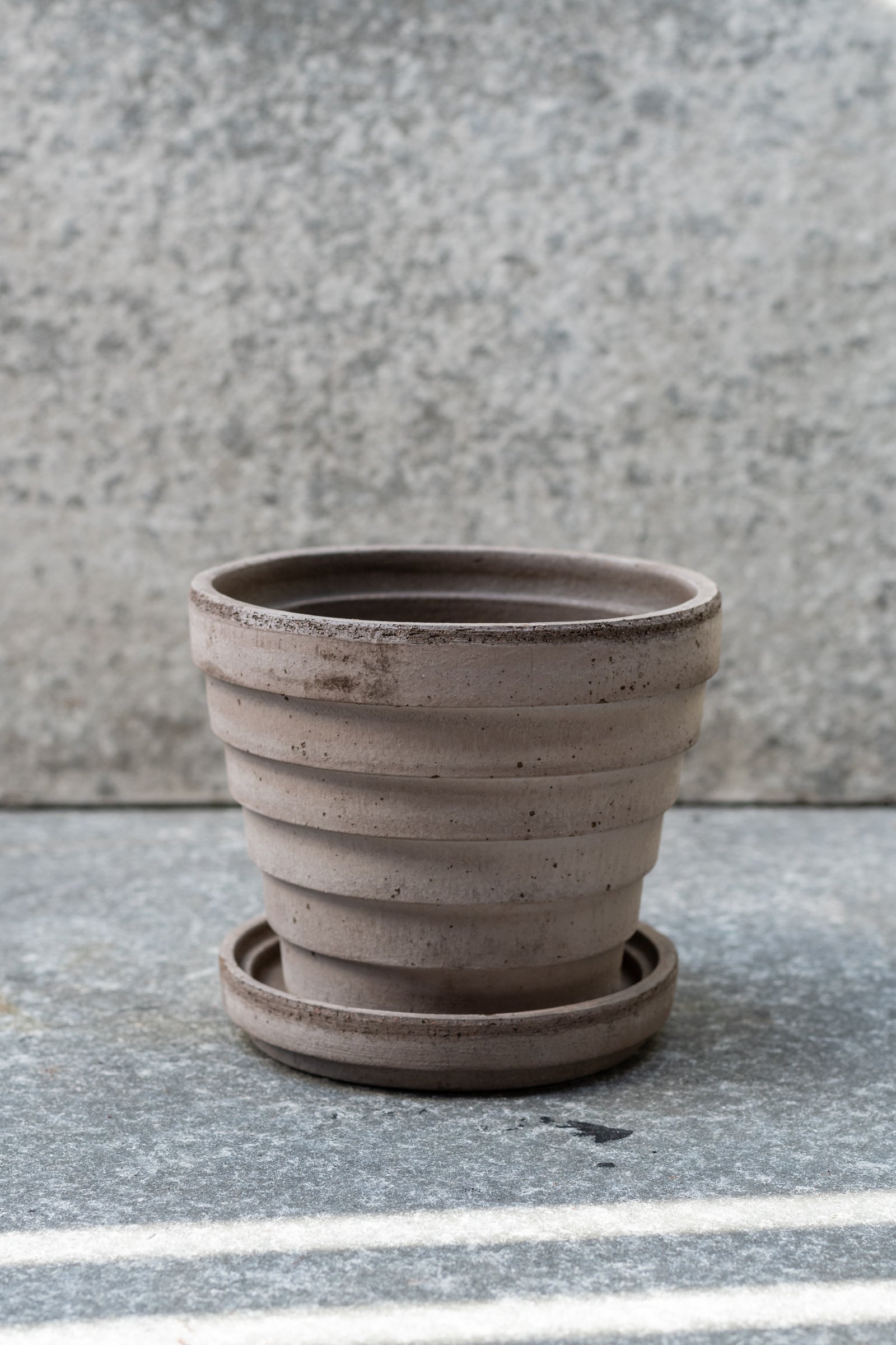 Grey 5.5 inch Planets Pot by Bergs Potter on a grey surface with a grey background