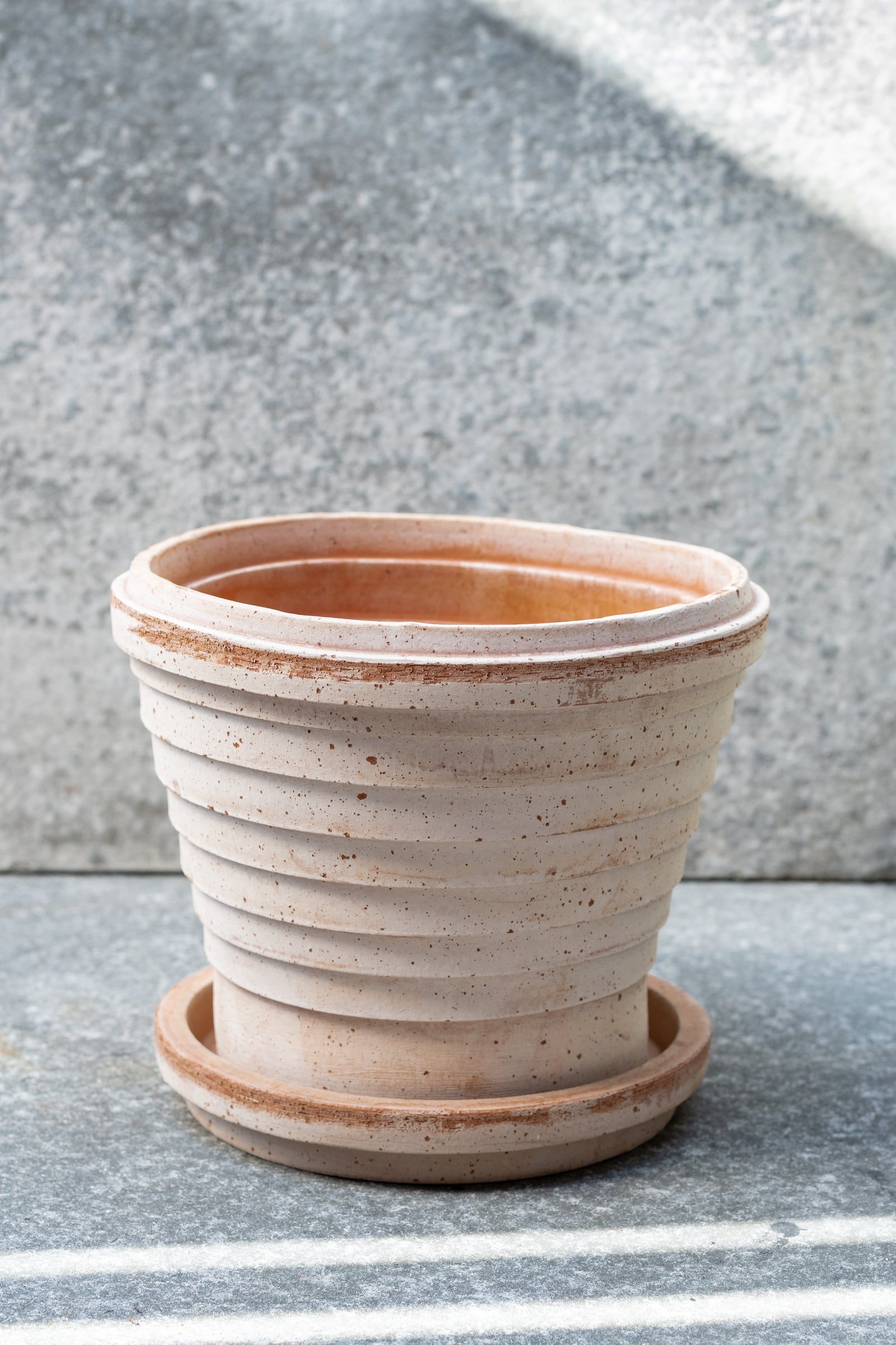 Rosa 8.3 inch Planets pot by Bergs Potter sits on a grey surface outdoors with a grey background