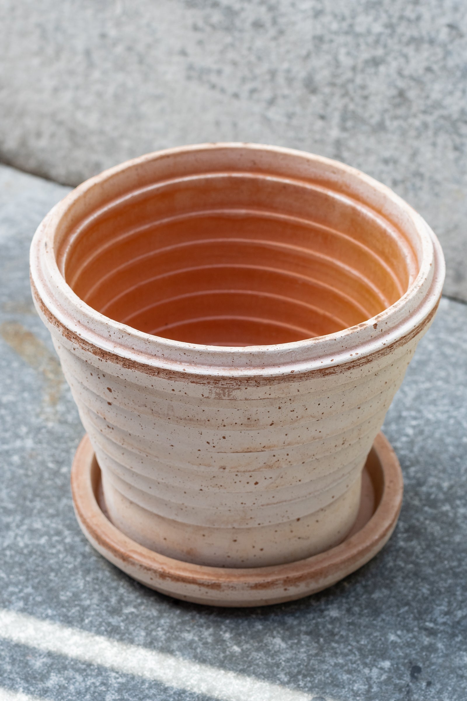 Rosa 8.3 inch Planets pot by Bergs Potter sits on a grey surface outdoors with a grey background