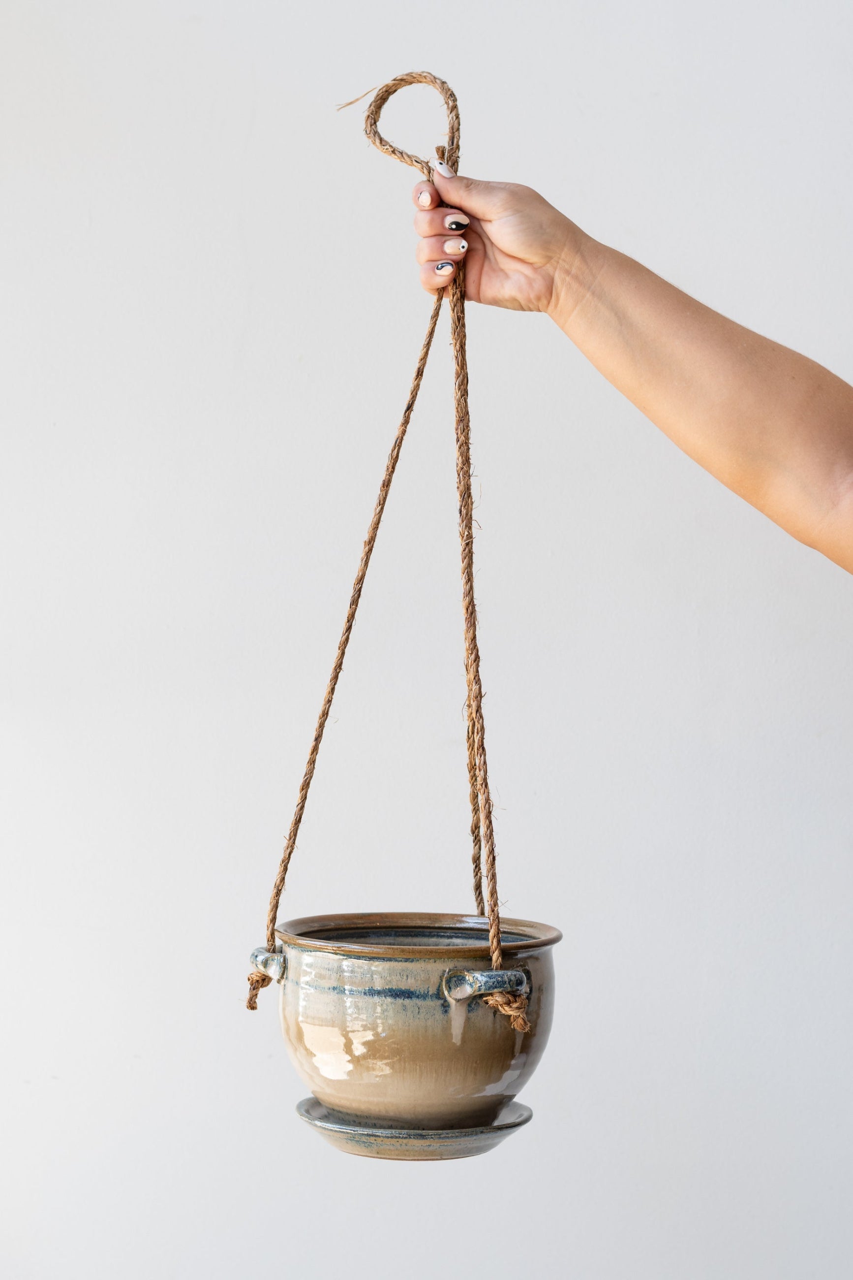 Bruning Pottery Hanging Planter ivory & iron glaze - 6" held in front of white wall ©Sprout Home