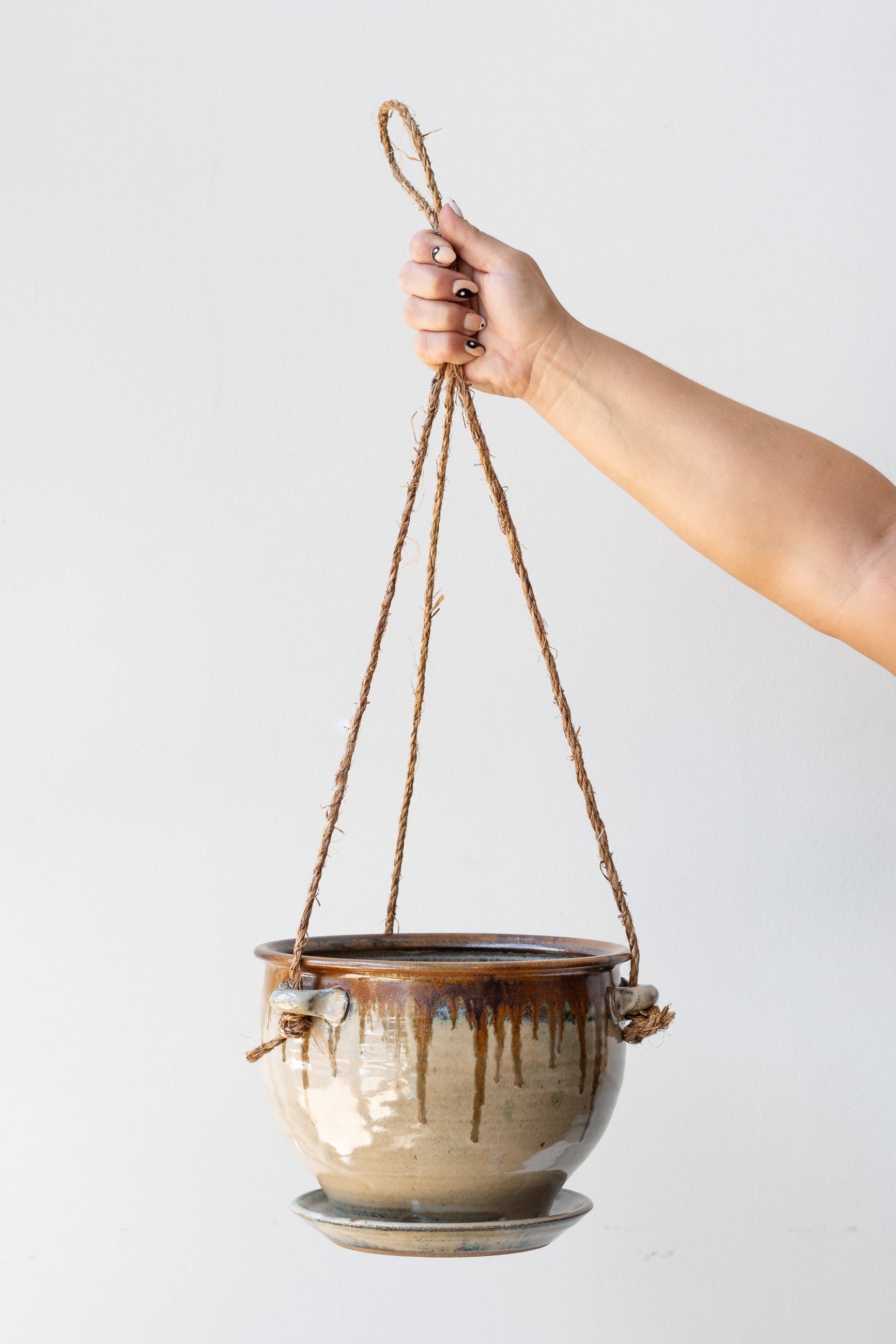 Bruning Pottery Hanging Planter ivory & iron glaze - 8" held in front of white wall ©Sprout Home