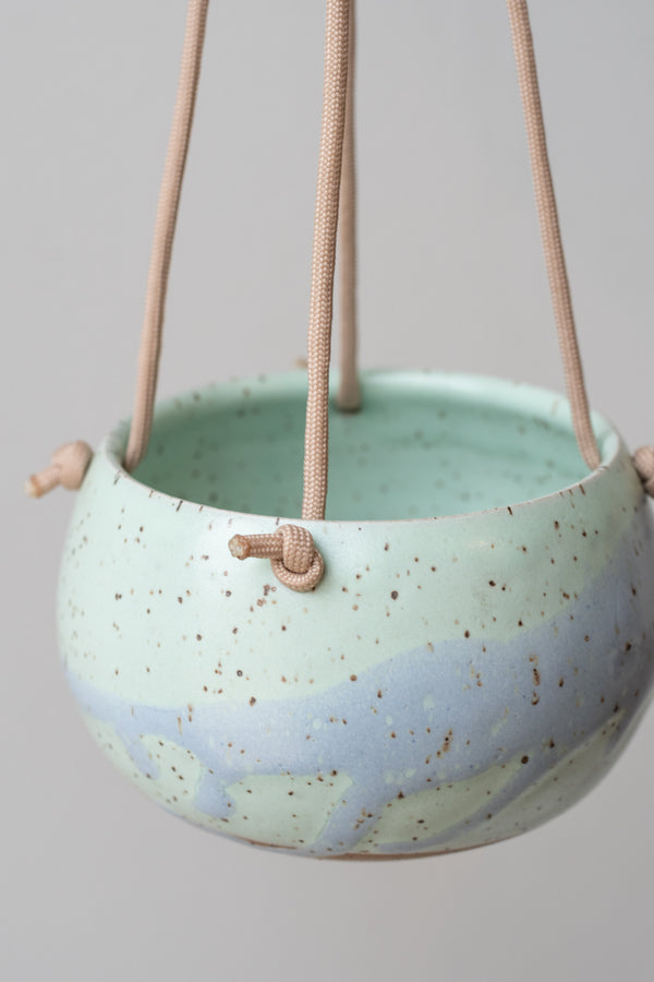 Close up of Miami Blue Orb Hanging Planter, light blue and mint glaze detail