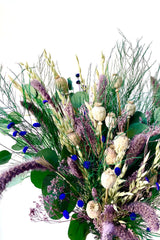 A close-up view of Plum Fizz Preserved floral arrangement by Sprout Home against a white backdrop