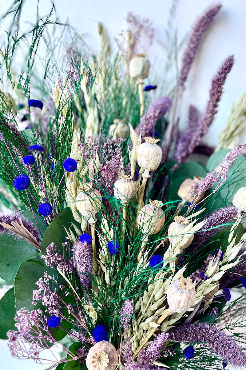 A detailed view of Plum Fizz Preserved floral arrangement by Sprout Home against a white backdrop