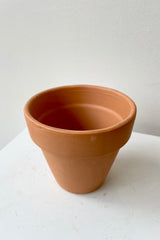 Detail of the top of Clay Standard Pot Terracotta 4.3" against a white wall
