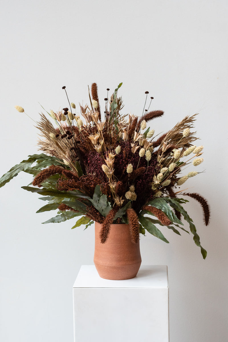 "Allspice" autumnal preserved floral arrangement by Sprout Home in terra cotta vase by Megan Sauve Ceramics in front of white background
