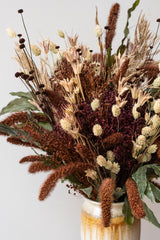 Close up of "Allspice" autumnal preserved floral arrangement by Sprout Home in ivory and iron Bruning pottery vase in front of white background