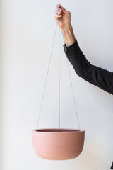 Angus and Celeste Raw Earth Hanging Planter ochre large held in front of white wall