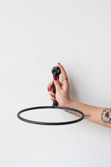 Tattooed arm with red nails holding 8 inch black flowerpot ring by Achla
