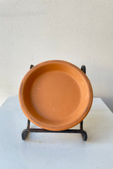 Clay Standard Saucer Terracotta 4.3" against a white wall