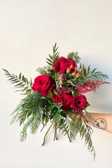 A hand holds an example of fresh Floral Arrangement Solstice at $60 from Sprout Home Floral in Chicago