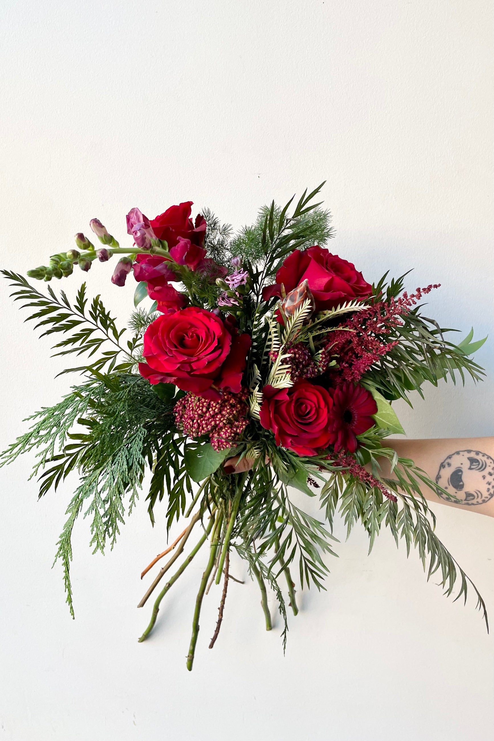 A hand holds an example of fresh Floral Arrangement Solstice at $90 from Sprout Home Floral in Chicago ©Sprout Home #size_$100