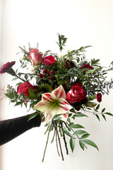 A hand holds an example of fresh Floral Arrangement Solstice for $60 from Sprout Home Floral in Chicago