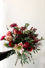 A hand holds an example of fresh Floral Arrangement Solstice for $85 from Sprout Home Floral in Chicago