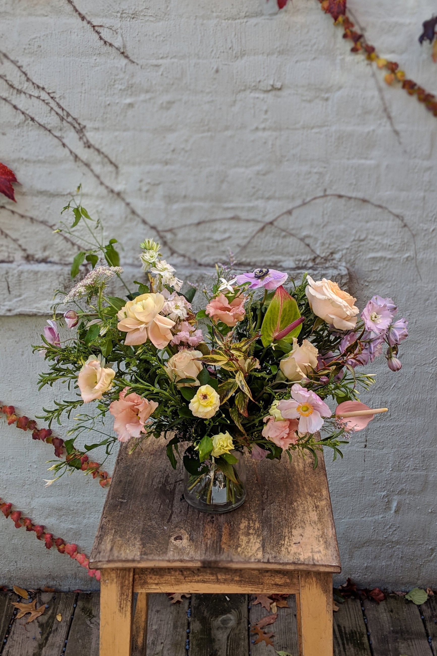 An example of Floral Arrangement Dawn from Sprout Home in Chicago. The arrangement is made of pastel yellow, purple, green, pink, and white flowers with green foliage. ©Sprout Home #size_$160