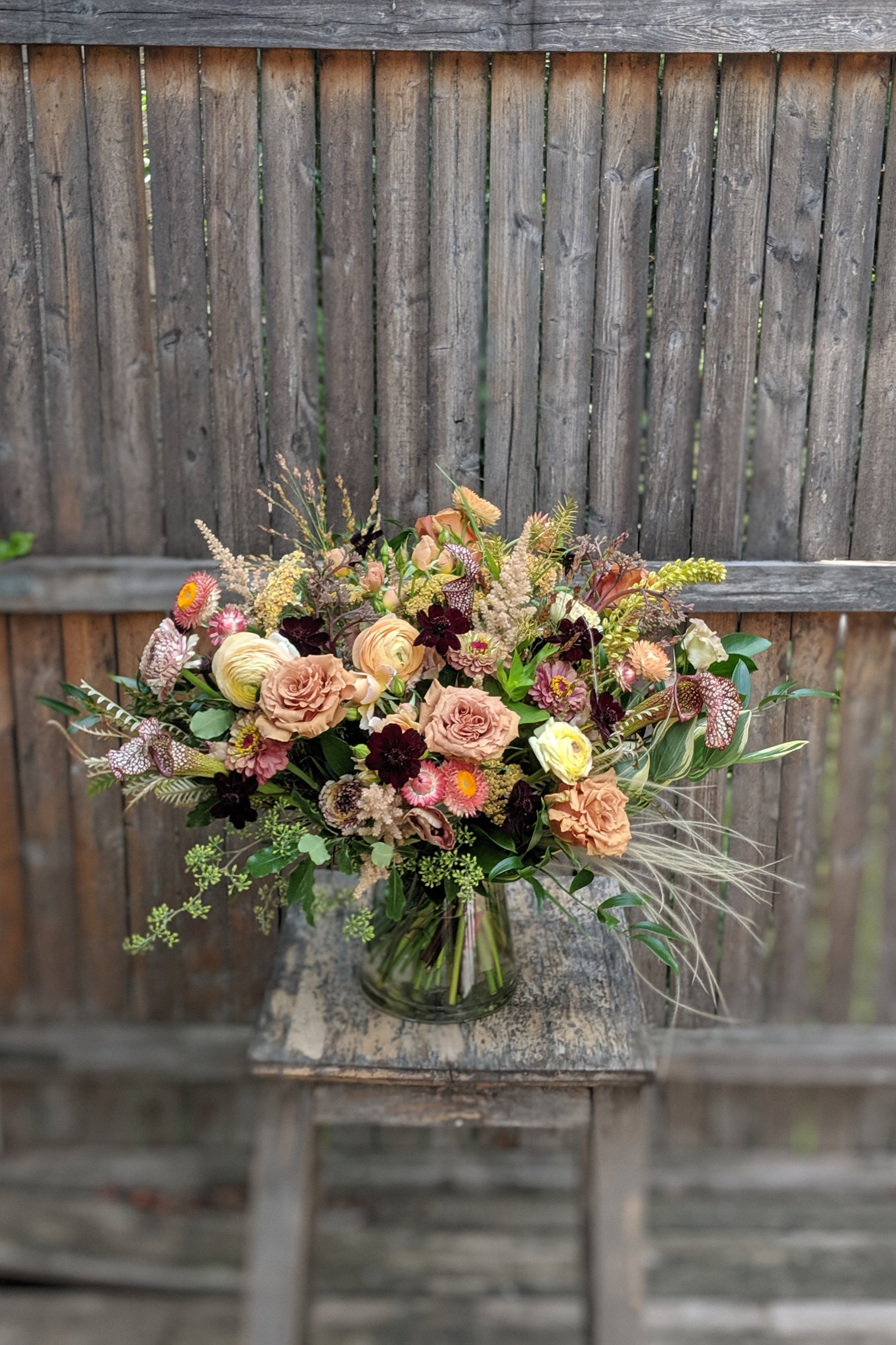A detailed view of an example of Floral Arrangement Dusk  in front of a wood fence with whispy elements from Sprout Home in Chicago ©Sprout Home #size_$160