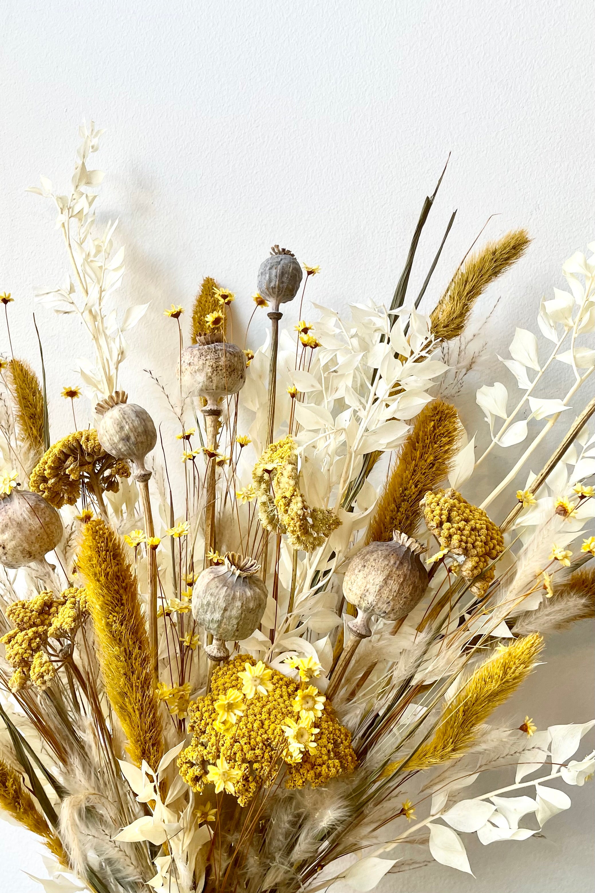 Textured dried floral arrangenment that fills the majority of the picture with bright yellows, tans and whites. All with a white background #size_$125