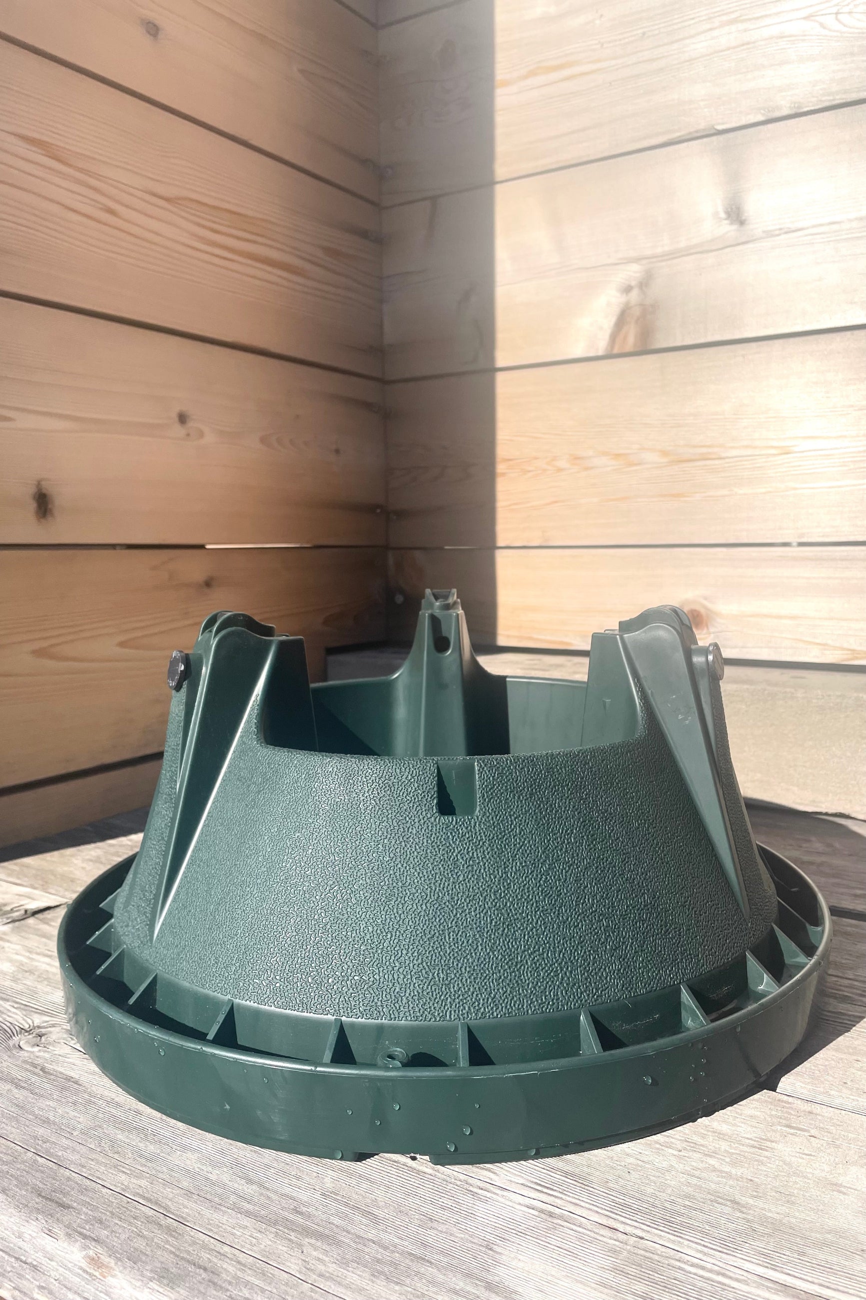 A frontal view of Cinco Xmas Tree Stand up to 8' against wood backdrop ©Sprout Home