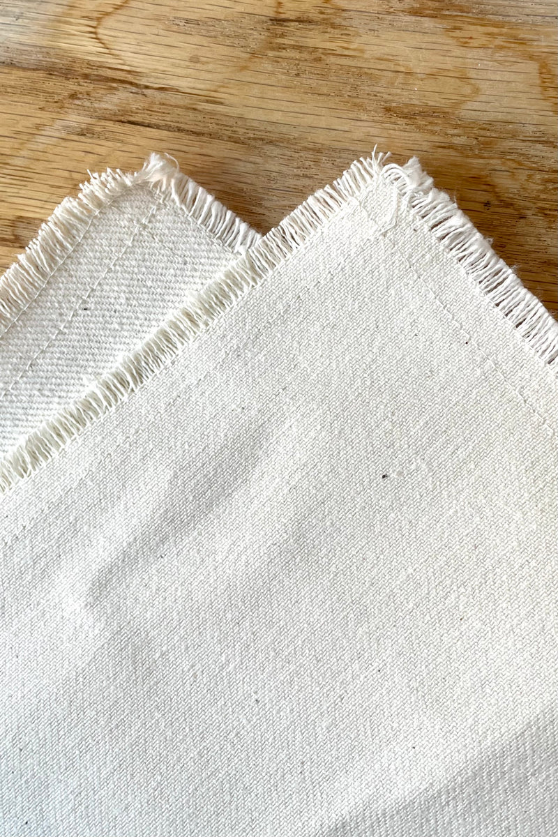 A detailed view of the Raw Denim Napkin against a wood background