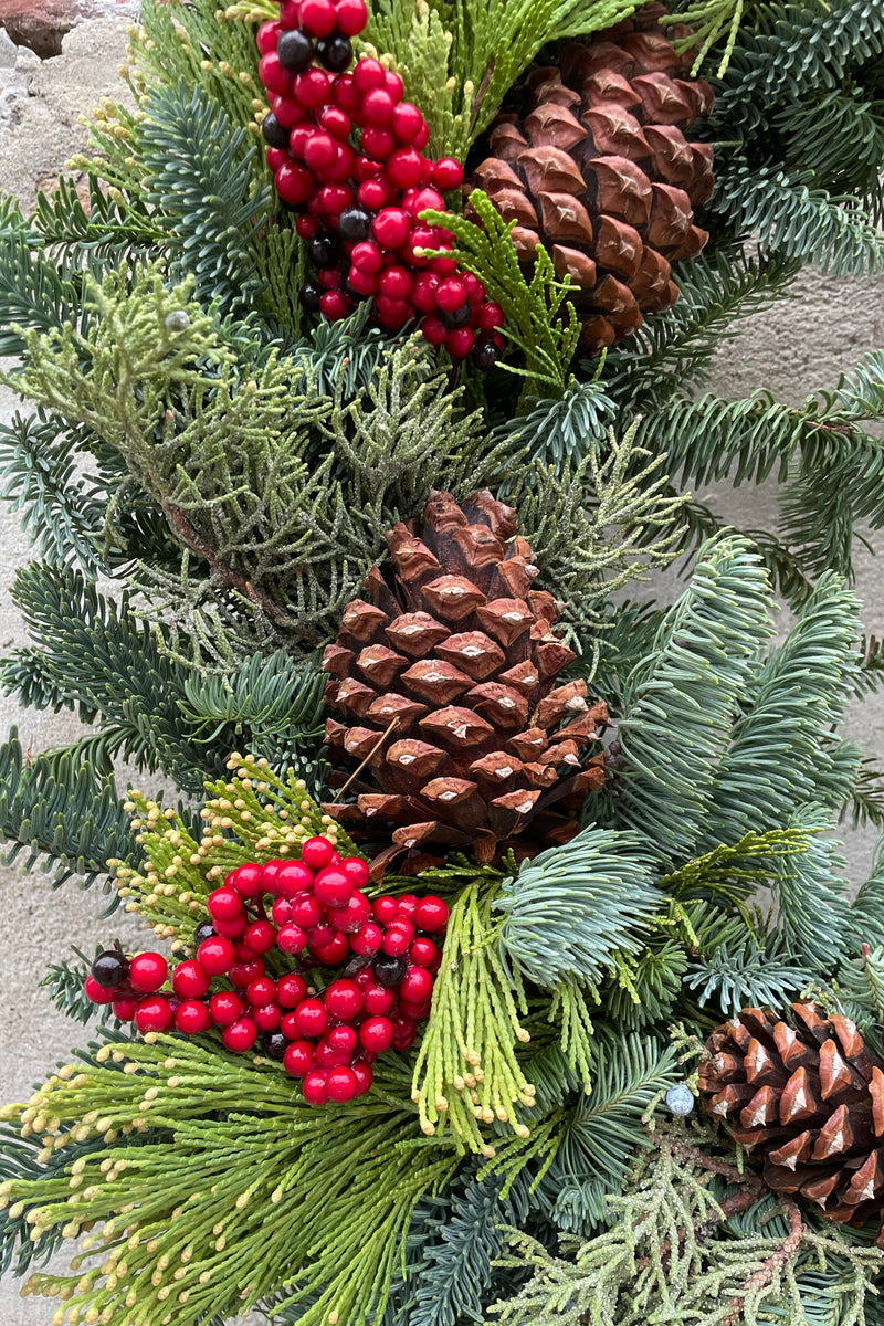 detail of the pine cone and faux canalaberry wreath