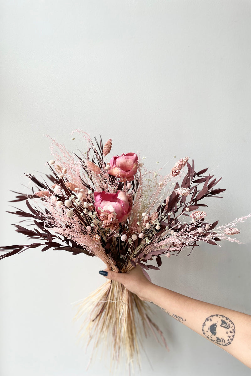 Chocoberry preserved floral arrangement by Sprout Home against a white wall. 