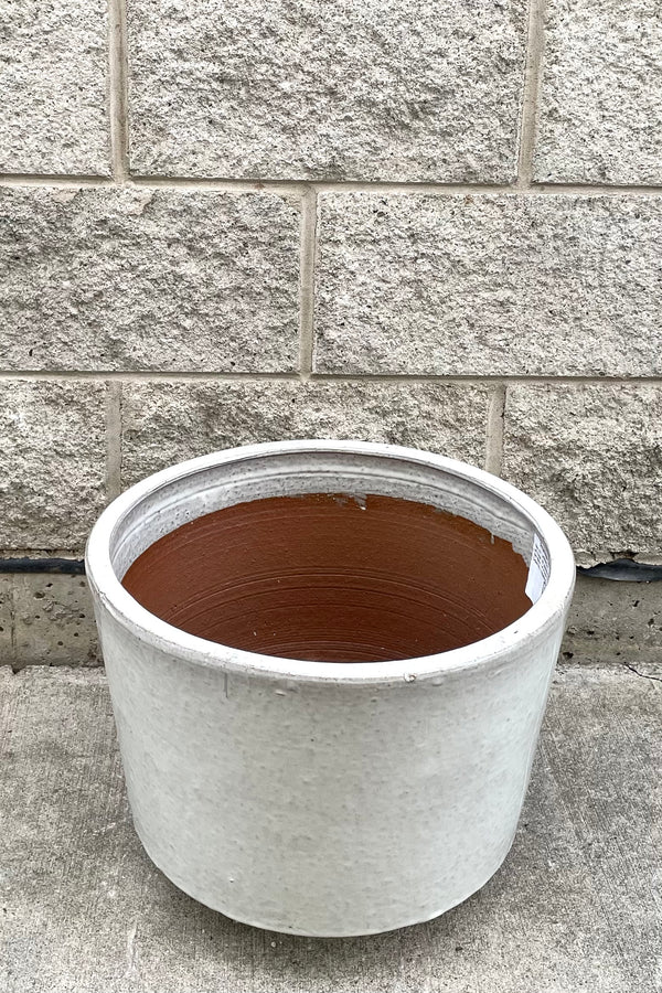 A slightly overhead view of Lara Oyster White Planter Medium against concrete backdrop