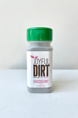 Joyful Dirt Succulent Fertilizer against a white wall