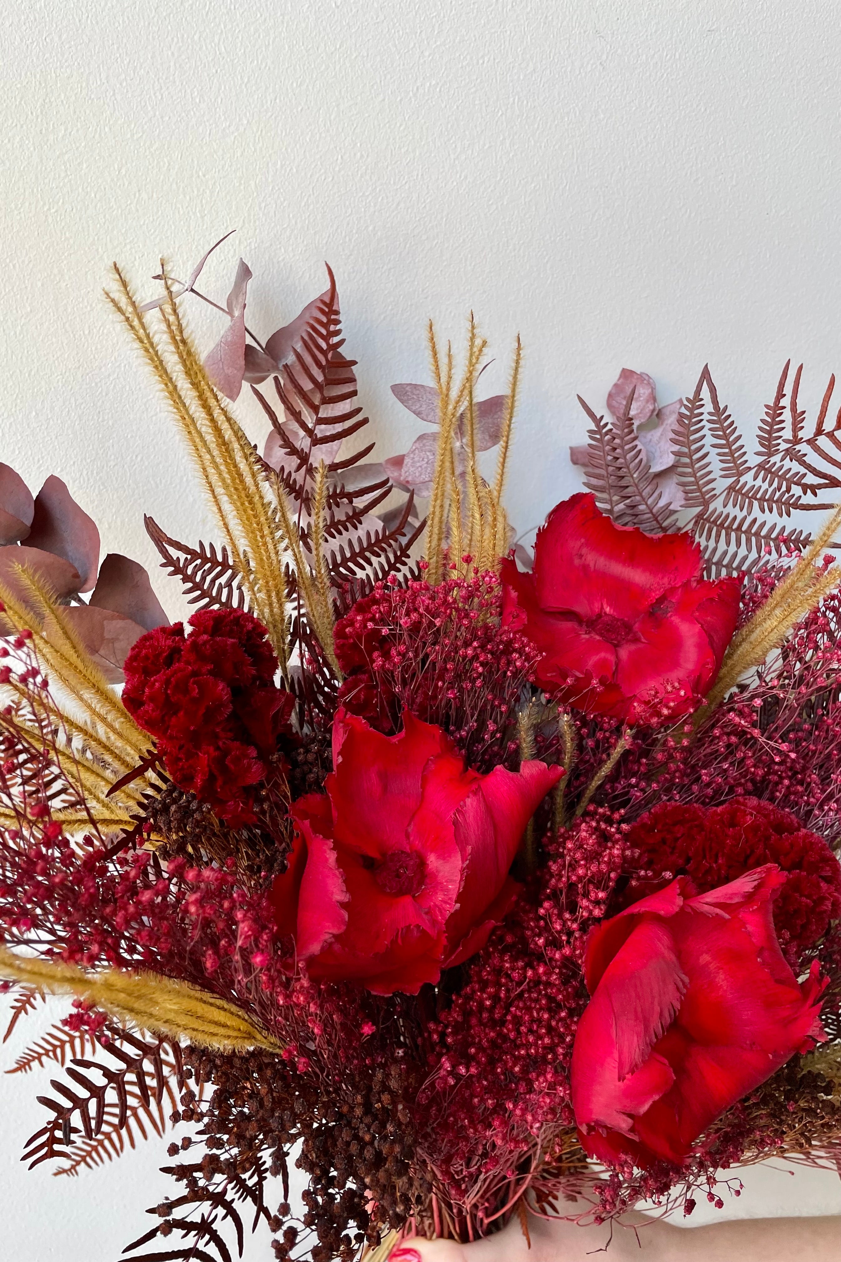 Preserved Red Velvet arrangement detail against a white wall #size_$125