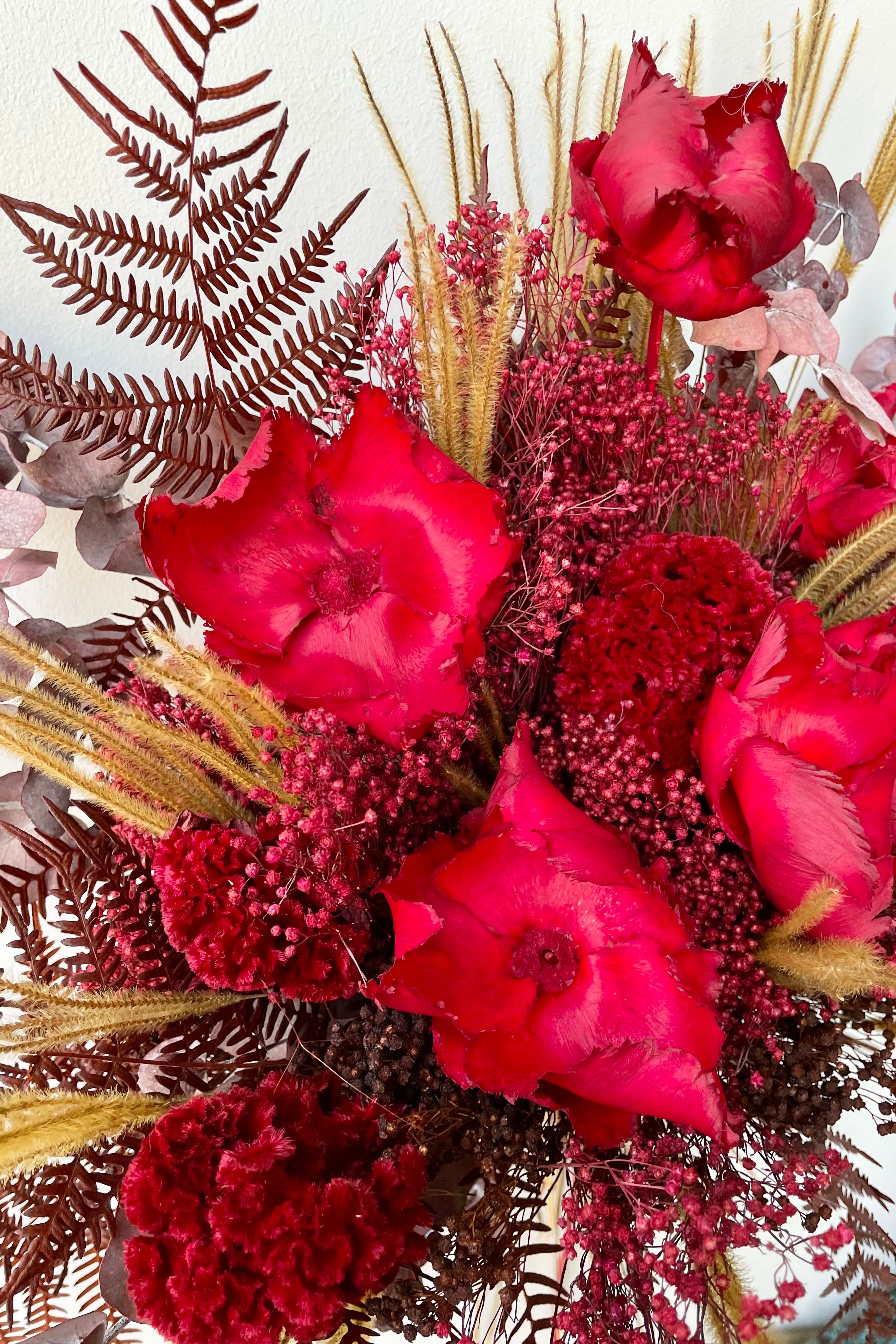 Preserved Red Velvet arrangement detail against a white wall #size_$160