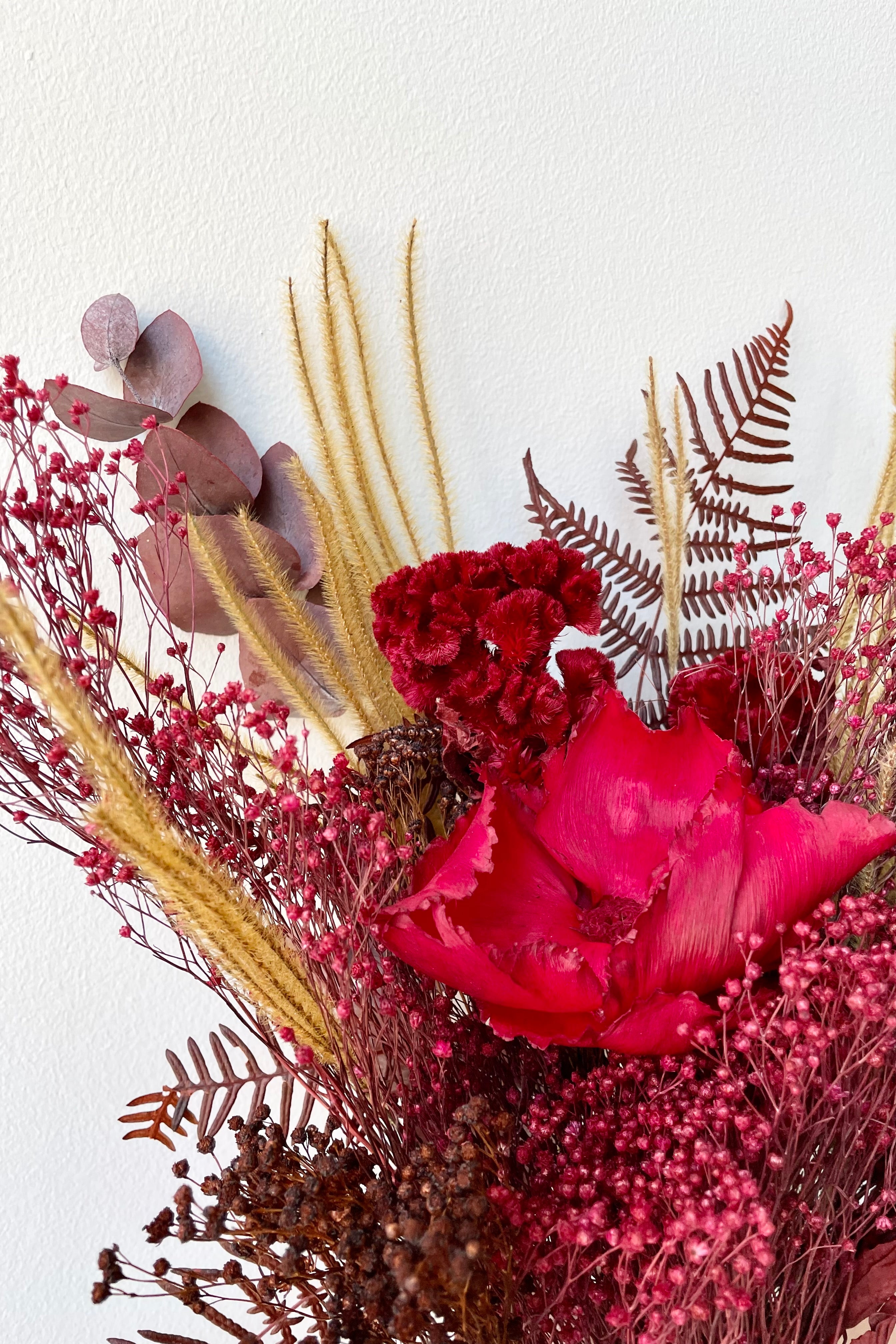 Preserved Red Velvet arrangement detail picture against a white wall #size_$60
