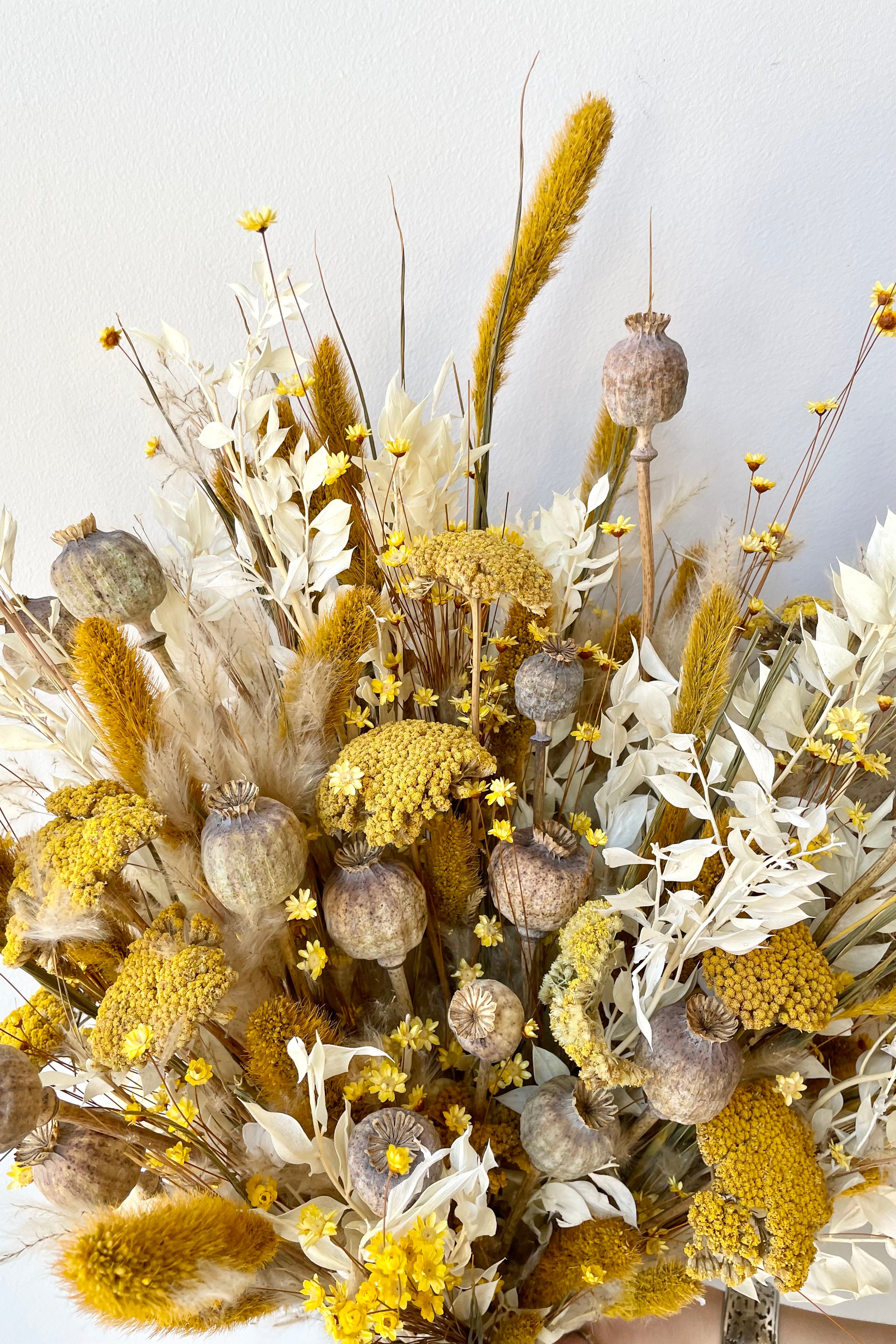 Full dried floral arrangement, with flowers, pods, a bleached greenery. The arrangement is filled with bright yellows, whites, and tans. #size_$200