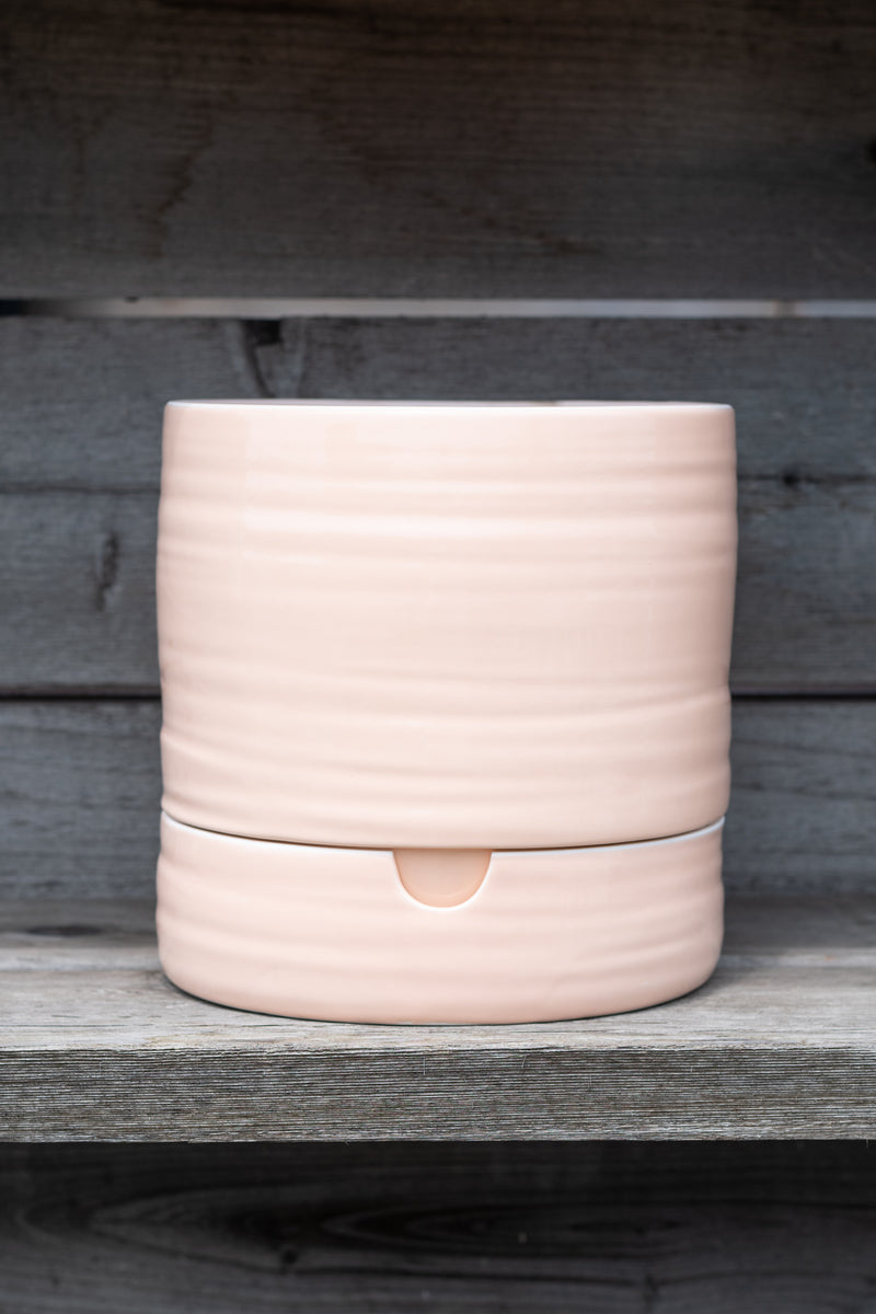 Self-Watering Plant Pot burnt coral tall by Angus and Celeste in front of grey wood background