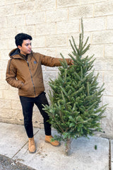 A man holds a variation of Fraser #1 Premium 3–5' Christmas tree