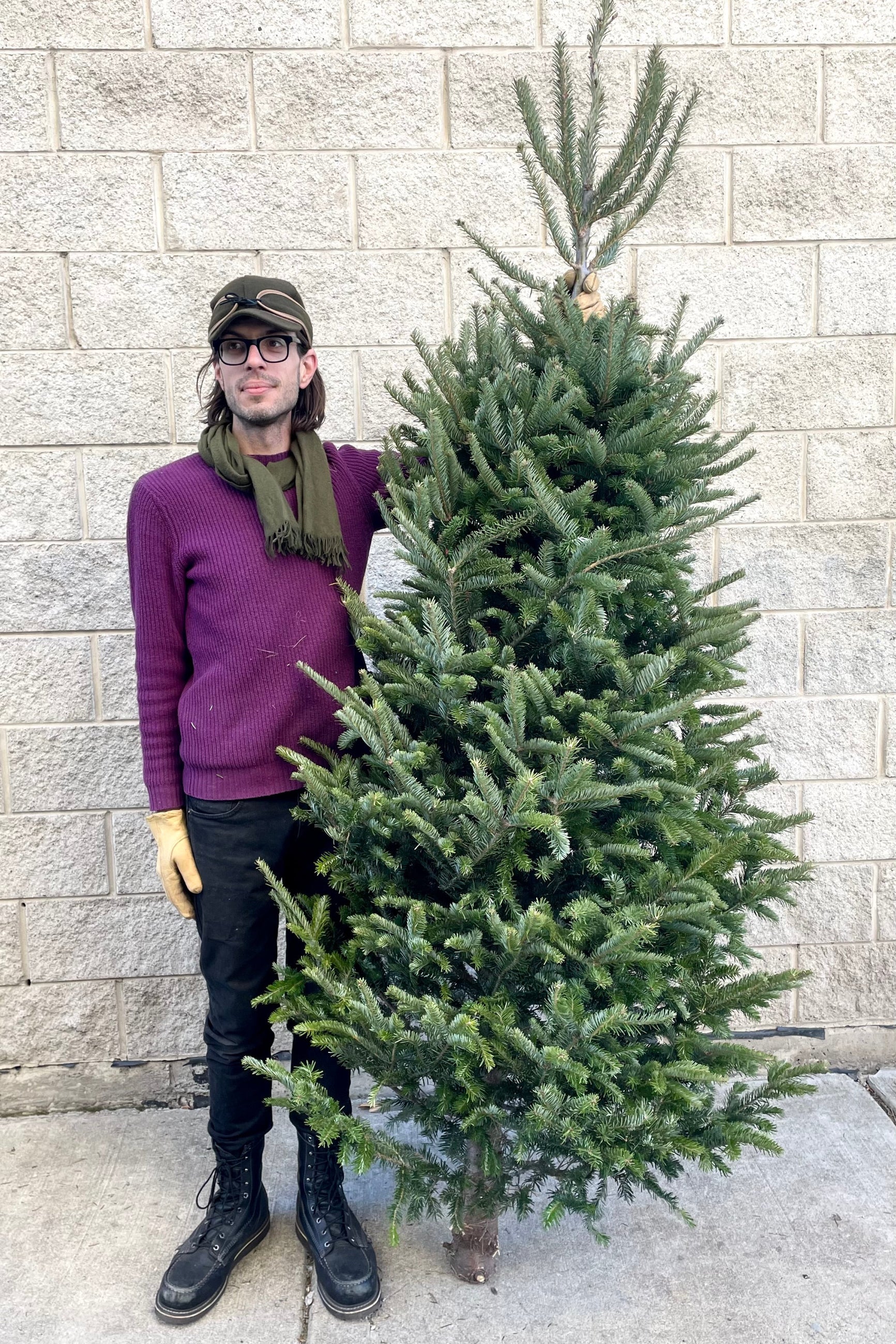 A man holds one variation of Balsam #1 Premium 7–8' Christmas tree ©Sprout Home